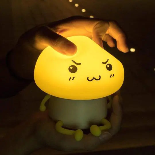 Cute rechargeable mushroom night light lamp with cartoon face, emits soft yellow LED glow, perfect for kids room decor or nursery.
