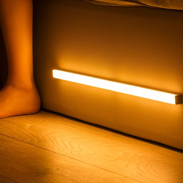 LED Sensor Light Bar illuminating floor with warm glow, motion-activated, perfect for home or office, enhances visibility, energy-efficient.