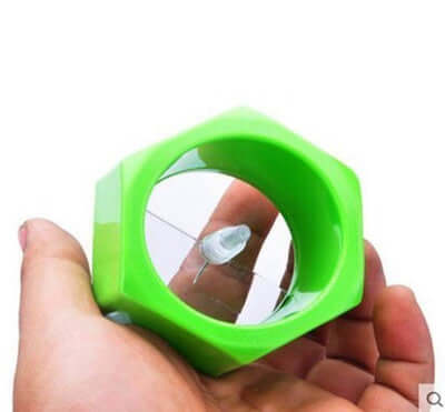 Hand-held green spiral knife vegetable cutter for slicing cucumbers and veggies.