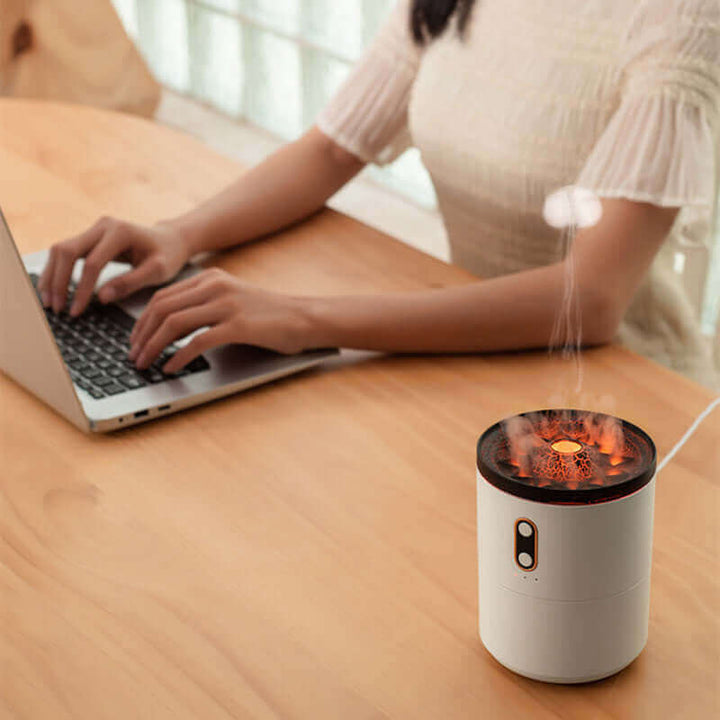 Volcanic Flame Aroma Diffuser on desk, USB Jellyfish humidifier emitting mist, laptop in background, cozy workspace setup.