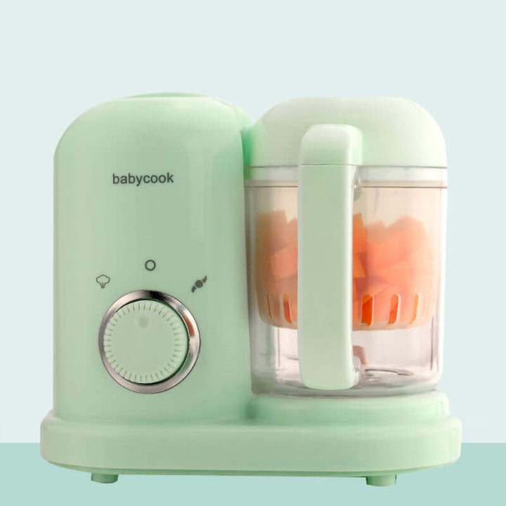 2-in-1 baby food processor and steamer in soft green with diced carrots inside the blending jar.