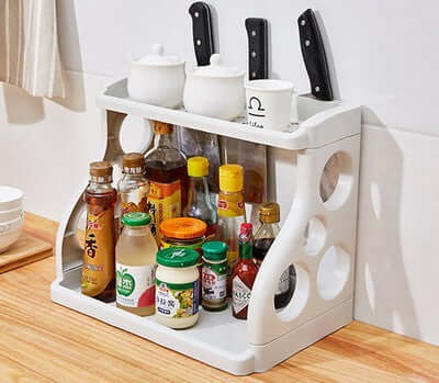 Multilayer kitchen storage shelving holding spices and utensils, perfect for space-saving, biophilic design, and sustainable materials.
