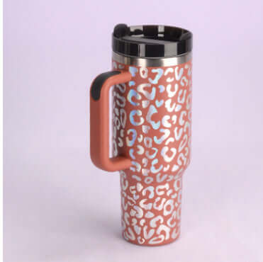 Leopard print stainless steel tumbler with handle and spill-proof lid, suitable for hot or cold drinks, perfect for home decor lovers.