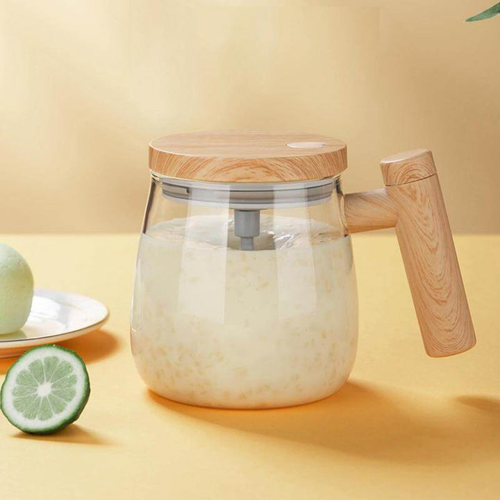 Transparent mixing cup with a wooden lid, used for self-stirring beverages on a yellow background, featuring cut lime slices.