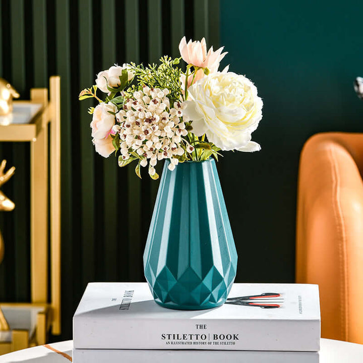 Teal Nordic style plastic vase with flowers on books, modern home decor