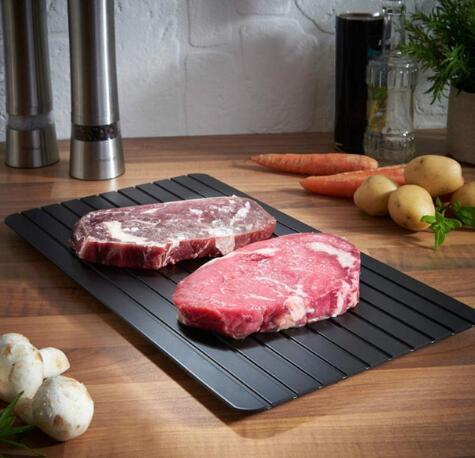 Fast Defrosting Tray on kitchen counter with steaks, carrots, and potatoes.