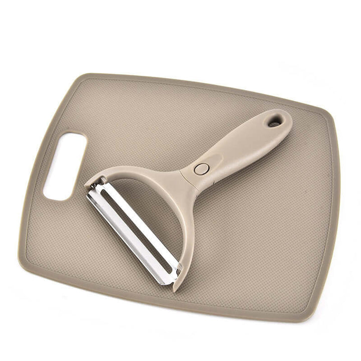 Stainless steel peeler on wheat straw chopping board, part of 3-piece eco-friendly cutter set for kitchen efficiency.