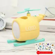 Yellow airplane-shaped LED night light on a desk with colorful details, USB rechargeable and ideal for kids' rooms and travel.