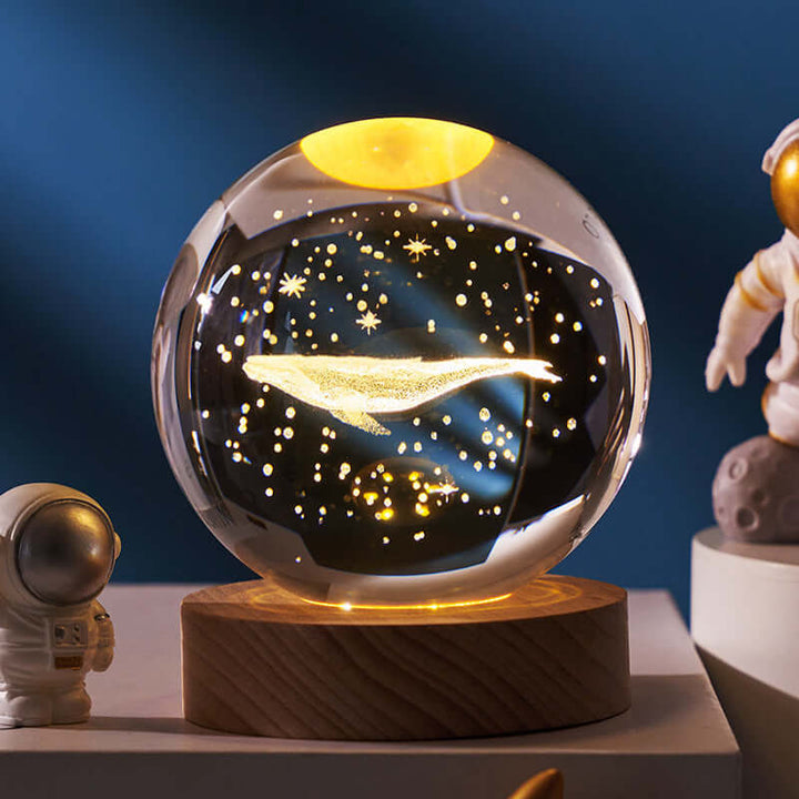 Whale-themed luminous crystal ball night lamp with celestial projections on wooden base, ideal for cosmic and ambient decor.