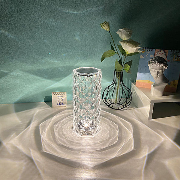 Nordic Crystal Touch Lamp on table with teal wall, casting intricate patterns, next to roses and decorative items, embodying Japandi style.