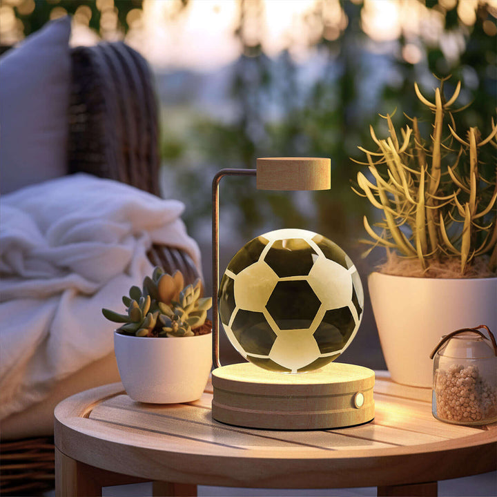 Crystal Ball Night Light with 3D design on a cozy outdoor table with plants and soft lighting.