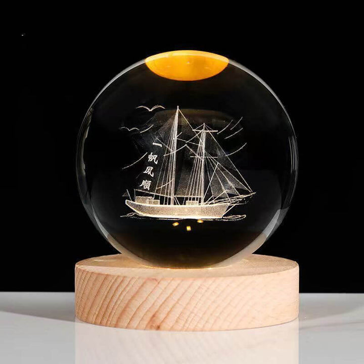 Crystal ball night lamp with engraved sailing ship on wooden base, creating a nautical-themed ambience light