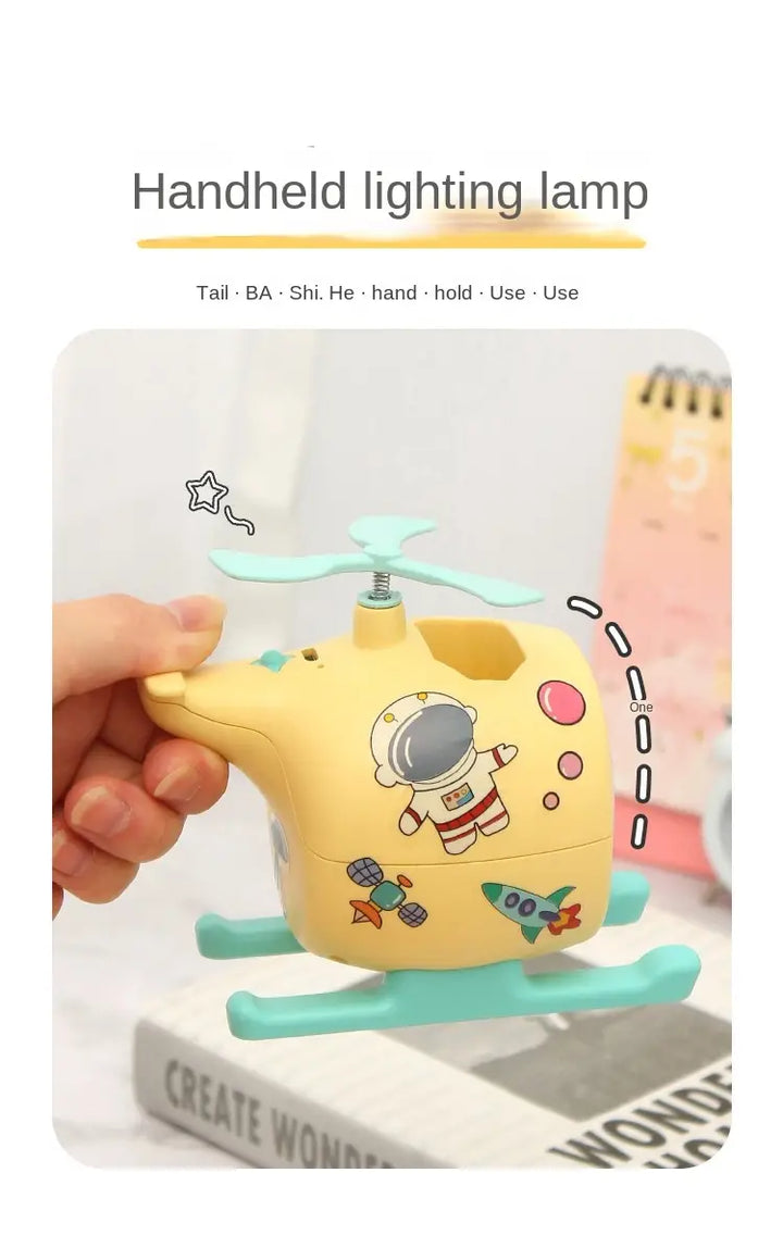 Handheld airplane-shaped night light with astronaut design and pastel colors, perfect for kids' rooms and easy to hold.