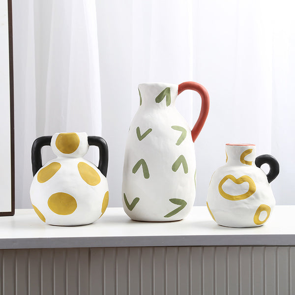 Artistic ceramic vases with abstract patterns in green, yellow, and black, ideal for modern biophilic decor.