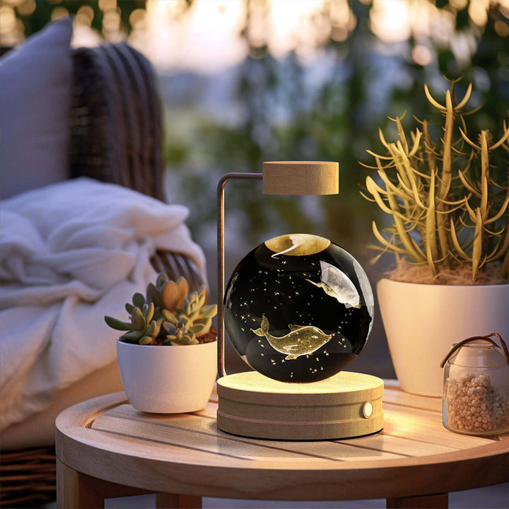 Crystal Ball Night Light on table with plants, featuring 3D dinosaur pattern, warm LED, and touch control for cozy ambiance.