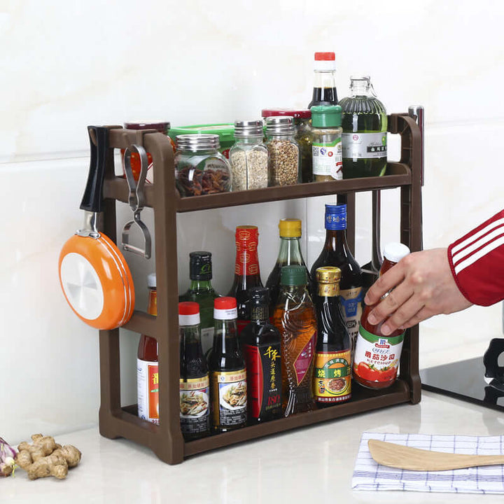Multilayer kitchen shelving with condiments, spices, and utensils on counter.