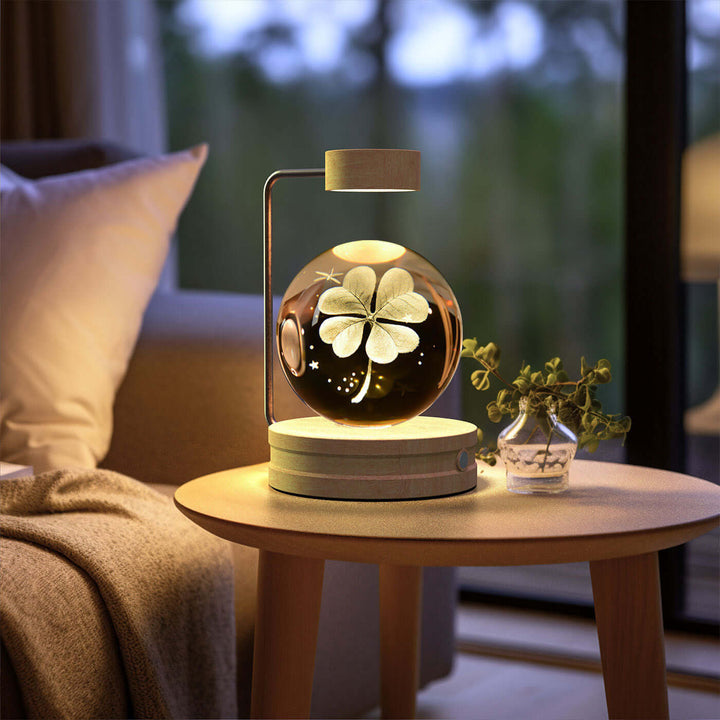 Crystal Ball Night Light with 3D pattern on bedside table, warm LED glow enhancing cozy reading nook atmosphere.