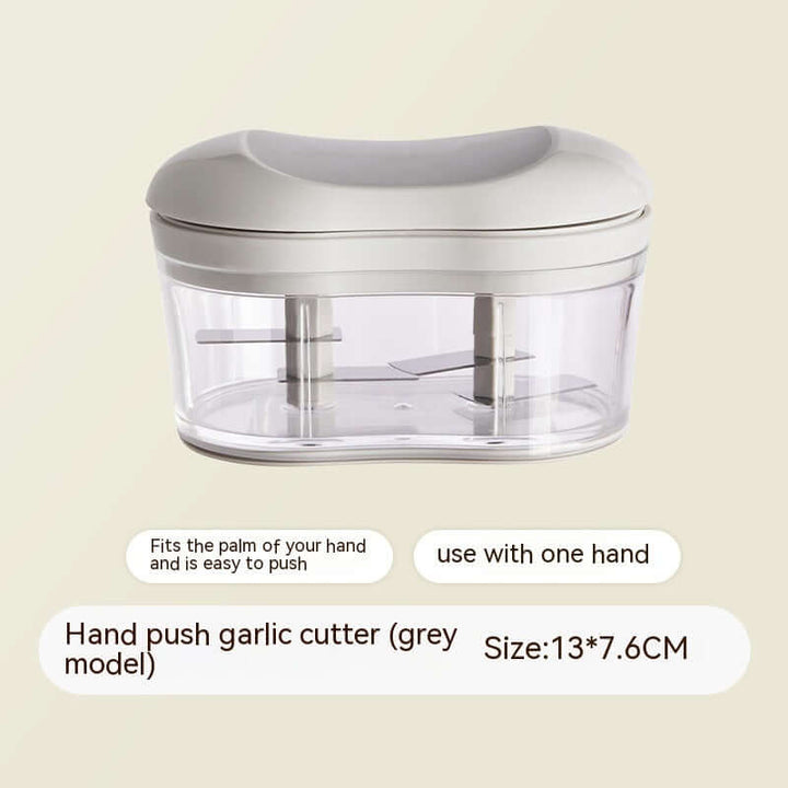 Hand push garlic cutter in grey with compact design, fits in one hand. Ideal for kitchen efficiency. Size 13x7.6 cm.