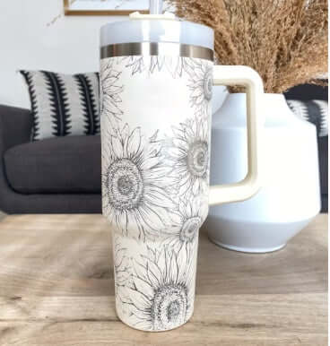 40 Oz sunflower-patterned insulated tumbler with handle, ideal for garden or home decor enthusiasts, on a wooden table.