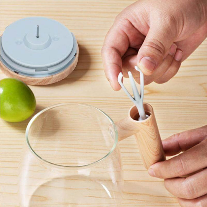 Person assembling 400ML Self-Stirring Coffee Mug with lime on wooden table.